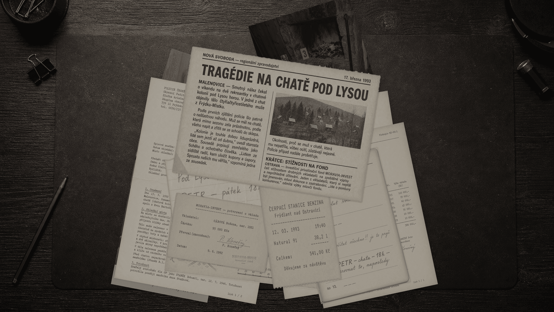 Spis rozložený na stole — protokoly, výpovědi, fotografie a mapy k případu